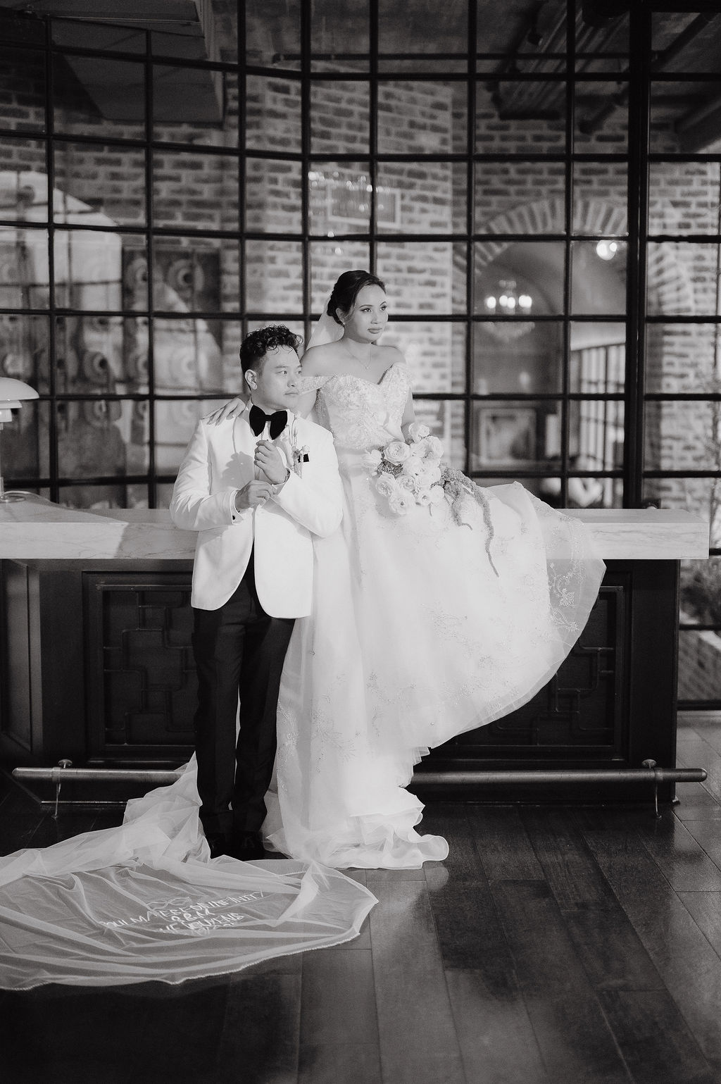 Bride and groom pose on bar at houston wedding venue