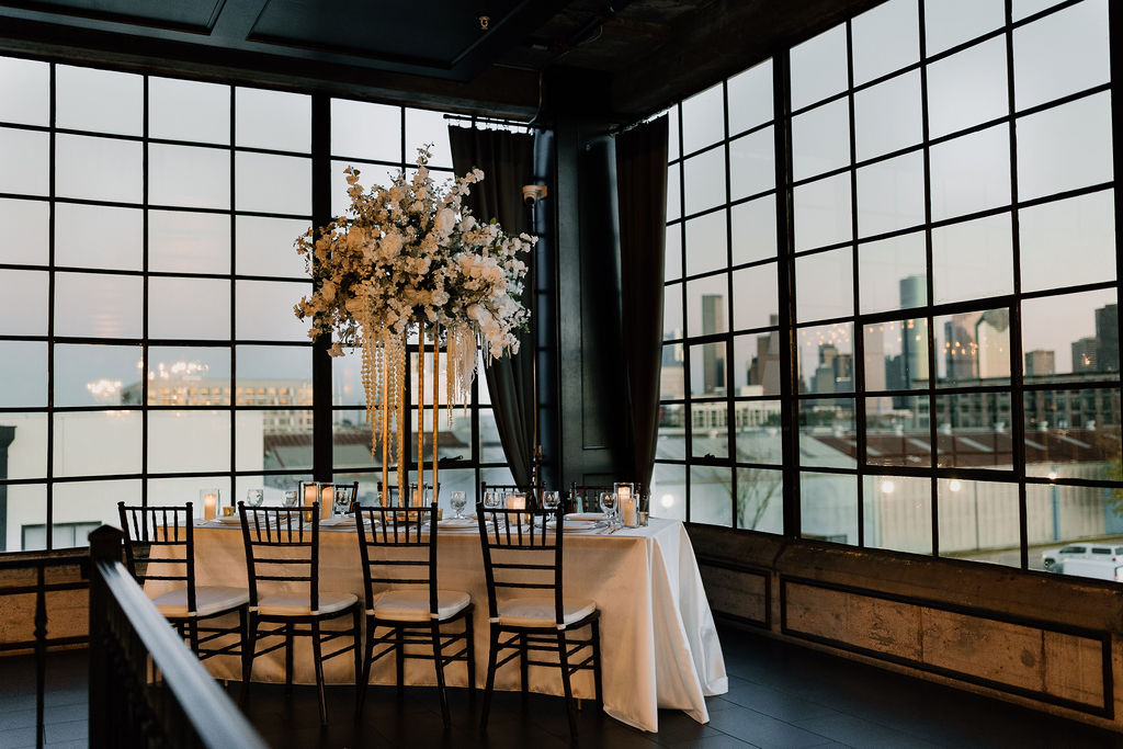 Reception table at The Astorian wedding venue in Houston with skyline views and tall floral centerpieces