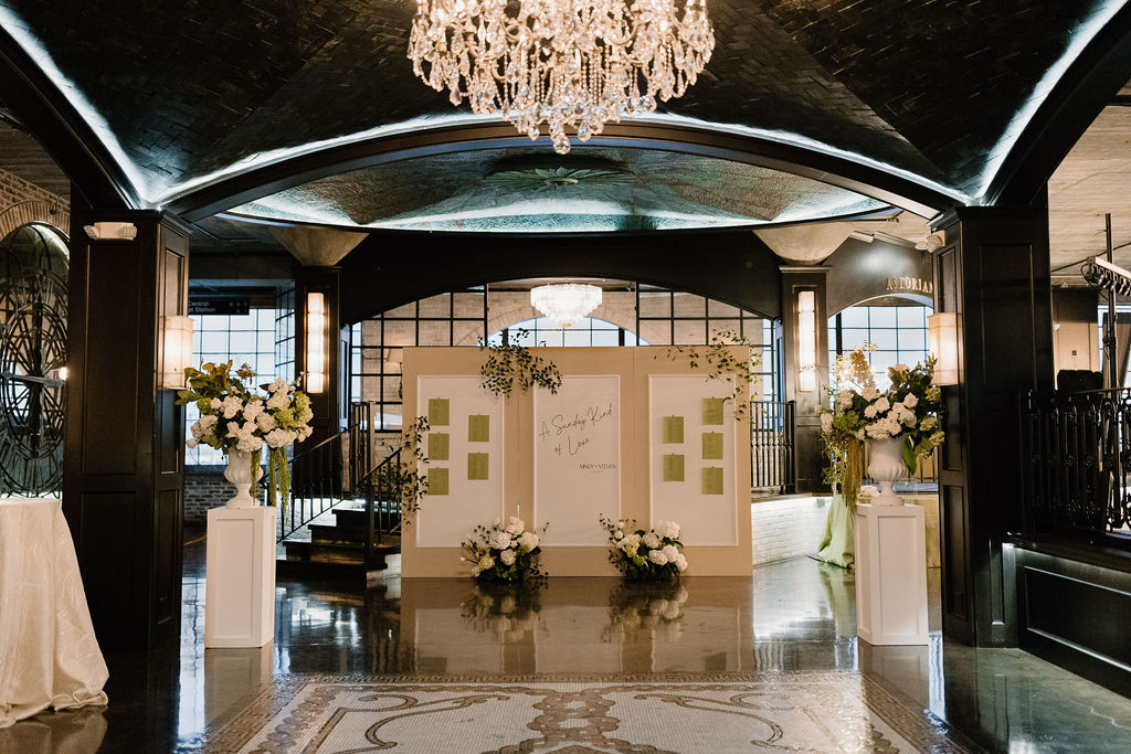 The Astorian wedding venue lobby in Houston with chandeliers, floral arrangements, and arched ceilings